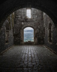 Dramatic Interior View of an Old Stone Building with a Mountainous Landscape in the Distance