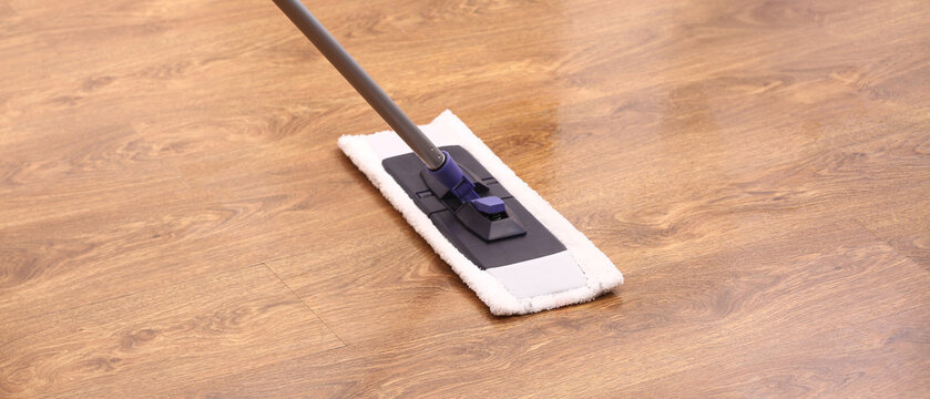 Cleaning of wooden laminate floor with mop and detergent