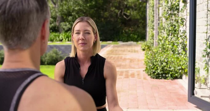 Yoga instructor giving calming remarks and guiding breathing exercise on brick patio with yoga mats