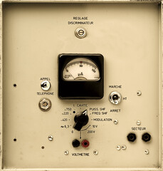vintage electronic control panel detail with analog rotary dial, switchs and meter