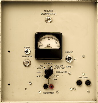 vintage electronic control panel detail with analog rotary dial, switchs and meter