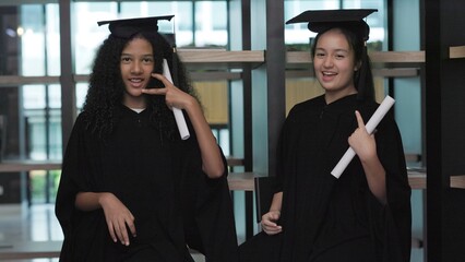 Two teenage girl students are happy on their graduation day