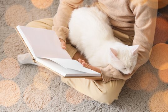 Little boy with cute cat reading book at home