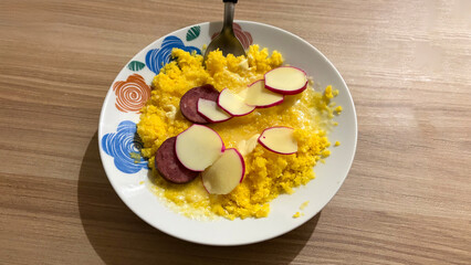 Savory Scramble: A vibrant close-up captures a plate laden with fluffy scrambled eggs, topped with perfectly sliced salami and potatoes, all presented with culinary finesse. 