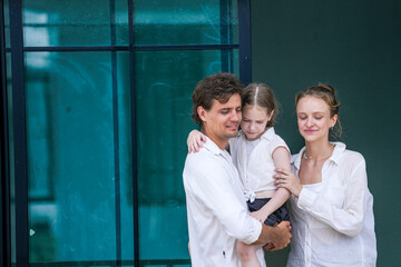 Obraz premium A happy young family at their new home. The father holds his excited daughter and points forward, sharing a moment of joyful discovery and planning for the future with his smiling wife.