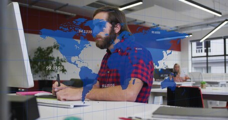 Man making notes at desk, stylus tapping tablet while blue map overlay annotating data analytics