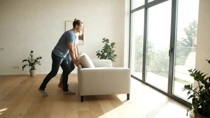 Young Caucasian couple working together on a home improvement project, carefully moving a sofa into their new sunlit modern apartment