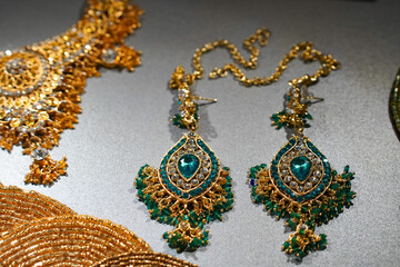 Russia, November 1, 2024:Vintage luxury Indian gold earrings with exquisitely shaped green gemstones harmoniously complement exquisite jewelry