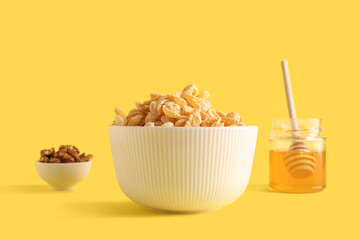 White bowl with tasty cornflakes on yellow background