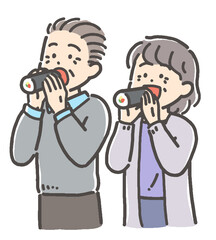 節分の恵方巻（太巻き）寿司を食べるシニア男女カップル