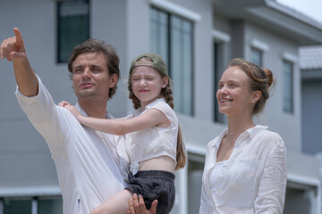 Obraz premium A beautiful moment of family affection as loving parents kiss their happy daughter's cheeks. The family shares a tender embrace, symbolizing love, security, and a happy home life.