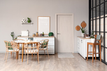 Interior of stylish kitchen with dining table, counters and white door