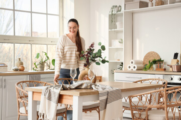 Young woman near dining table in kitchen