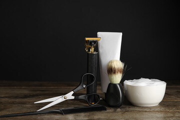 Male shaving accessories with modern trimmer on wooden table