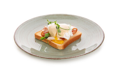 Plate of delicious egg Benedict with bacon and micro green on white background