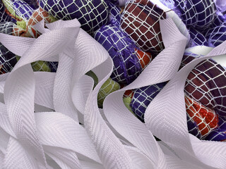 pieces of white ribbon with a rough texture on a woven fabric background