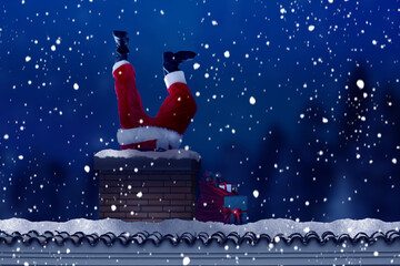 Santa Claus crawling into chimney under falling snow at night. His legs sticking out of smokestack