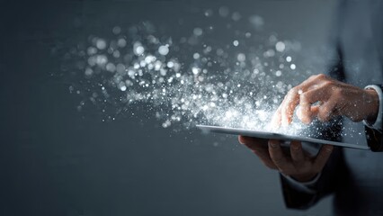 Businessman interacting with digital tablet displaying abstract glowing particles