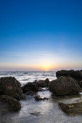 sunrise on the coast with limestone rocks in the foreground