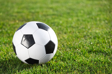 Fototapeta premium Soccer ball on green stadium grass, closeup