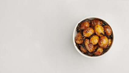 Korean braised baby potatoes with soy glaze, Gamja Jorim, top view, copy space