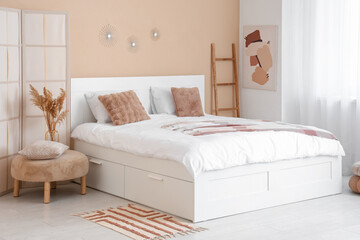 Interior of stylish room with bed, folding screen and ladder