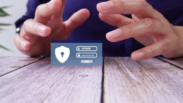 Close-up of a pair of hands on a table, shielding a blue user login interface animation.