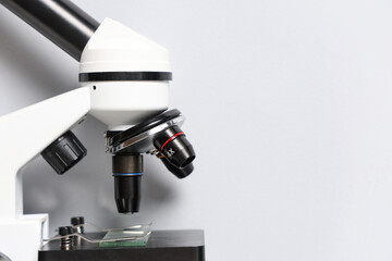 Closeup view of modern microscope on white background