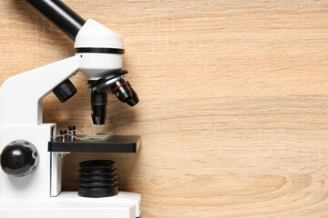 Modern microscope on wooden background