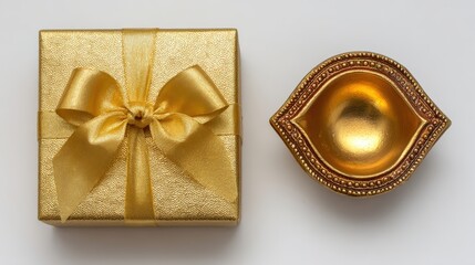Shiny golden gift box and decorative oil lamp positioned side by side on a plain background