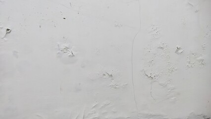 White peeling paint texture on a cracked wall, showing moisture and poor maintenance.