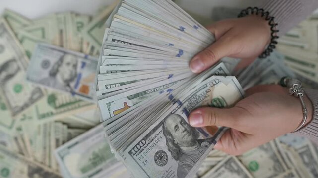 luxurious hands display money, closeup of glamorous woman presenting cash and jewelry, upscale female hands elegantly fanning money amid jewelry and manicured nails for luxurious atmosphere