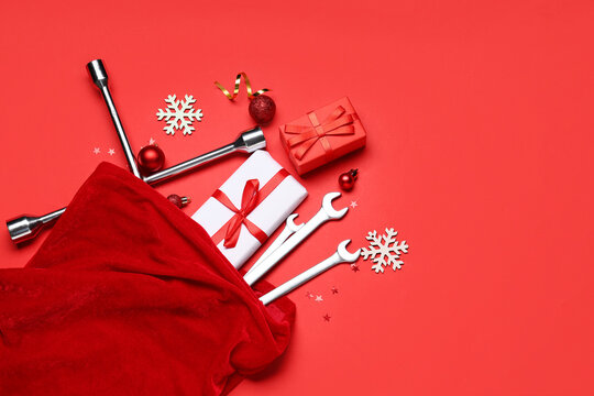 Santa bag with wrenches, presents and Christmas decor on red background