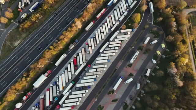 distribution center with parked trailers, aerial perspective showing organized loading areas, view from above depicting busy distribution terminal with trailers and scheduled activities