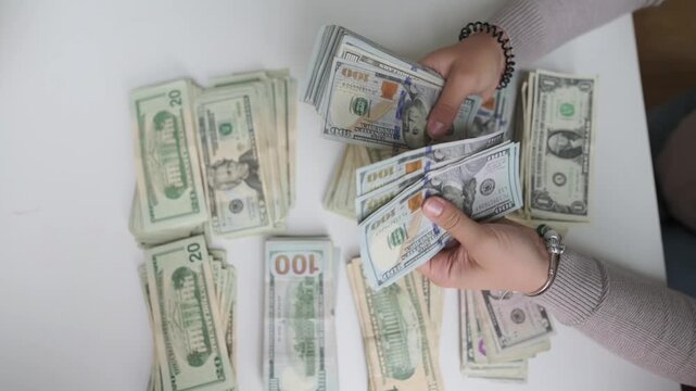 woman organizing payment documents, female worker preparing payroll and counting bills carefully, hands meticulously managing cash and organizing payment envelopes for payroll processing