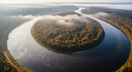 Aerial view of a river meander with autumn forest in the morning mist.