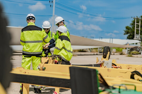 Engineers inspecting wind turbines at a renewable energy site. Wind energy professionals ensuring sustainable and clean energy production with advanced technology in a wind farm environment.
