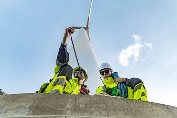Team of engineers in reflective work suits join hands to inspect and demonstrate their work and...