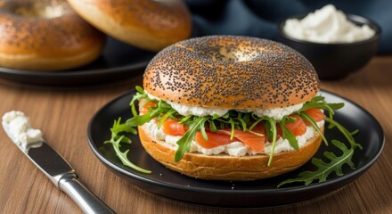 Bagel sandwich with cream cheese arugula and salmon on a black plate delicious breakfast or brunch