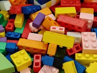 Heap of colorful, oversized plastic building blocks and construction bricks.