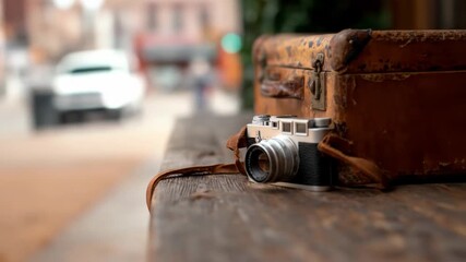 Vintage camera and weathered suitcase on old wooden bench capturing travel memories and classic photography equipment