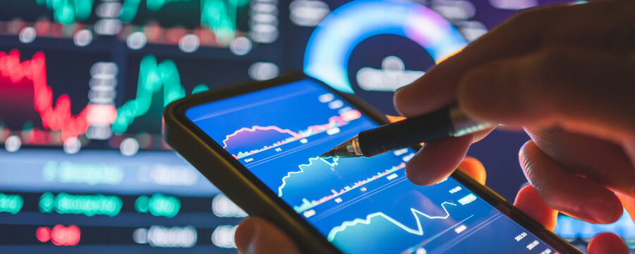 Analyzing financial data on a smartphone, with charts and graphs in the background