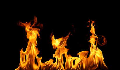 Fototapeta premium Bright orange fire flames on a black background create a dramatic and intense visual effect. Perfect for design, energy concepts, danger themes, or background use in advertising and digital art.