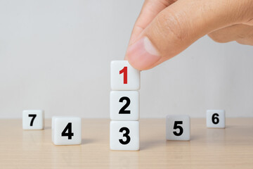 Task priority and management concept, The order of priority in any activity, Set work priority, arrange to do list. Hand arranging dice with number first, second, third, four, five, six, seven.