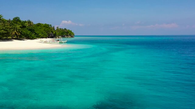 White sand beach and blue sea. Turquoise lagoon with clear sea water. Mahaba Island, Philippines. Summer and travel vacation concept.