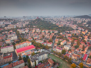Top view from the hill of Signal Park of red roofs and cityscape of old town and new town seaside of Qingdao, China. Seaside tourist town that is popular with Chinese people.