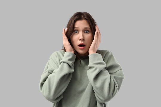 Scared young woman on light background