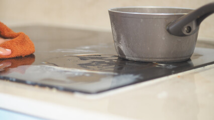 wiping electric stovetop with with cloth 