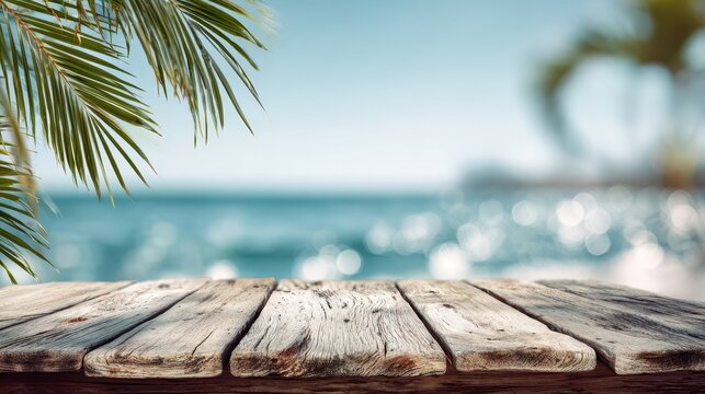 A Crystal Clear photo of ummer wooden plank table and sea with blurred palm leaves and defocused bokeh light on ocean, abstract landscape background.