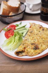 Delicious omelet served with fresh vegetables and bread